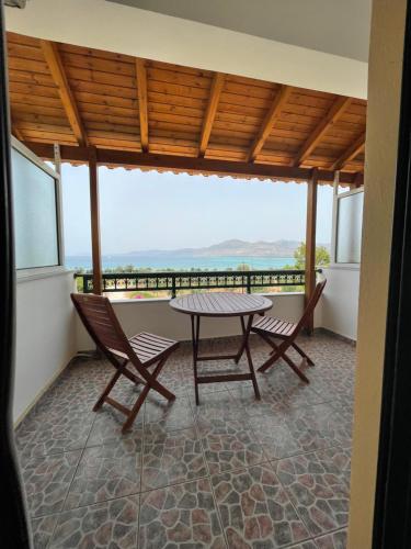 a table and chairs on a balcony with a view at Niriides Rooms in Elafonisos
