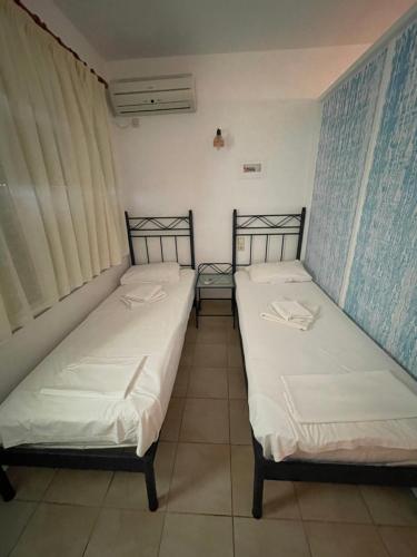 two beds sitting next to each other in a room at Niriides Rooms in Elafonisos