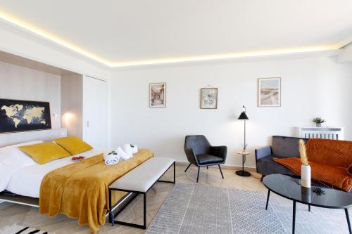 une chambre avec un lit, une chaise et un canapé dans l'établissement Suite Riviera - Sea View - Clim - 50M Plage - Residence de standing - Spacieux 180 M2 - Parking, à Cannes