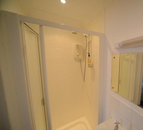 a white bathroom with a shower and a toilet at Marine View in Brighton & Hove
