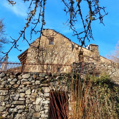 un ancien bâtiment en pierre avec un mur en pierre dans l'établissement Chambre ou Gîte dans une maison de montagne - De Suzon à Zélie, à Entraigues