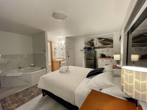 ein Schlafzimmer mit einem großen Bett und einer Badewanne in der Unterkunft Private Room On Waterfront Property With Hot Tub Firepit - Sea Esta in Ucluelet