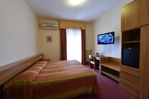 ein Hotelzimmer mit einem Bett und einem TV in der Unterkunft AMBRA HOTEL - The only central lakeside hotel in Iseo in Iseo