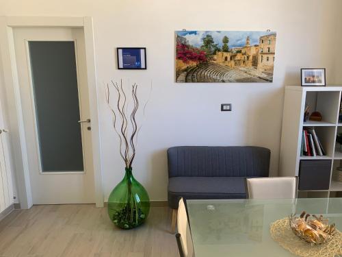 a living room with a glass table and a green vase at Casa Midori in Lecce