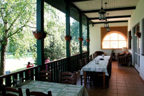 a restaurant with tables and chairs on a balcony at Vadászház Karád in Karád