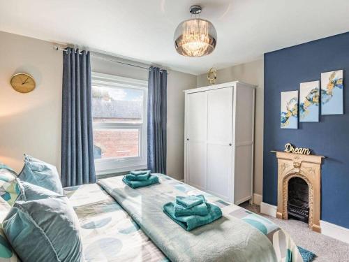 a bedroom with a bed with blue walls and a fireplace at Cathedral Quarter House with free Secure Driveway Parking for 2 Cars in Lincoln