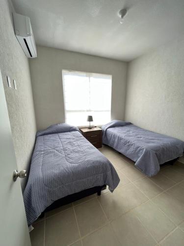 - une chambre avec 2 lits et une fenêtre dans l'établissement Casa Playa Turquesa, à Playa del Carmen