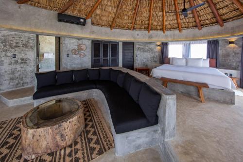 a bedroom with a bed and a couch and a bed at Maya Tulum By G Hotels in Tulum
