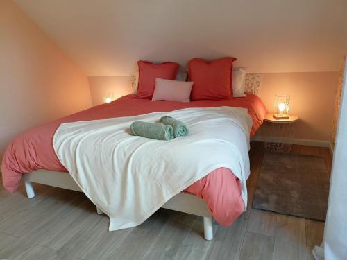 um quarto com uma cama grande e almofadas vermelhas em Les chambres d'hôtes DU VERT GALANT " l'Allée des champs" em Verlinghem