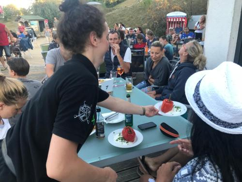 a man holding a plate of food at a table at Bungalow, Adler auf Rügen in Zirkow