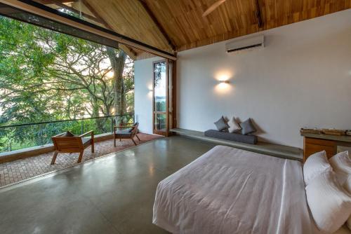 a bedroom with a bed and a balcony at Arachchi Heritage in Anuradhapura