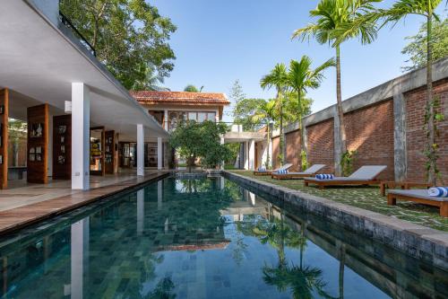 an infinity pool in a house with palm trees at Arachchi Heritage in Anuradhapura