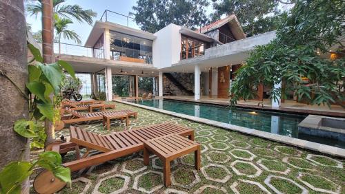 a house with a swimming pool and wooden benches at Arachchi Heritage in Anuradhapura