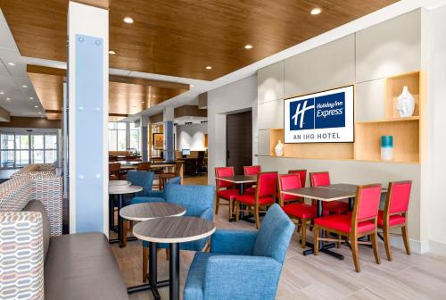 a restaurant with tables and chairs and a sign at Holiday Inn Express & Suites Sanford - Lake Mary by IHG in Sanford