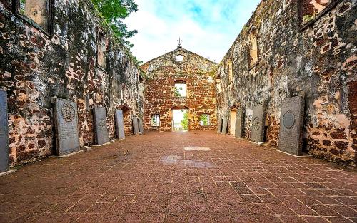 an empty alley with a brick building with a clock at J&J Vacation Home@Novo8 Residence in Kampong Tambak