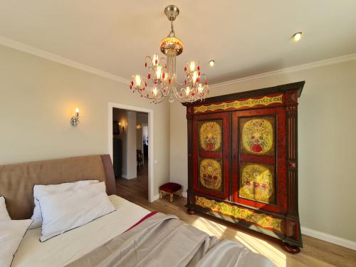 利耶帕亞的住宿－Barinu apartment，卧室配有一张床,墙上挂有绘画作品