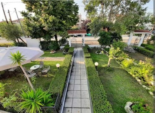 a garden with an umbrella and tables and chairs at Despoina House in Psakoudia