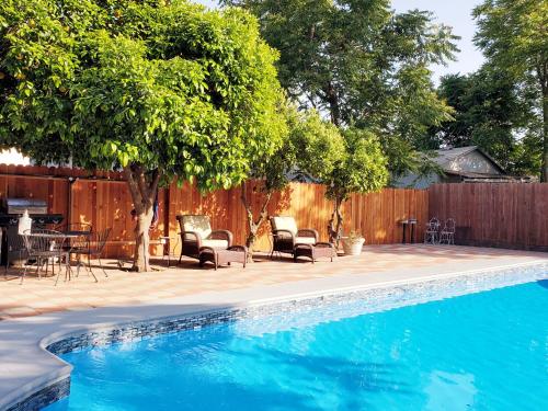 a swimming pool in a yard with chairs and a table at Garden Clara in Yuba City