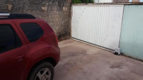 a red car parked next to a white gate at Casa Cantinho de Santarém in Santarém