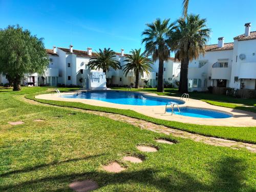 een zwembad voor een gebouw met palmbomen bij Denia playa montañas y mucho más in Denia