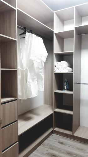 a walk in closet with white clothes and towels at 1 ком ТРЦ Костанай плаза in Kostanay