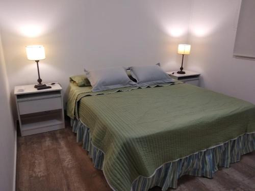 a bedroom with a bed and two night stands with lamps at Cabañas Campo Quijano - Desértico in Salta