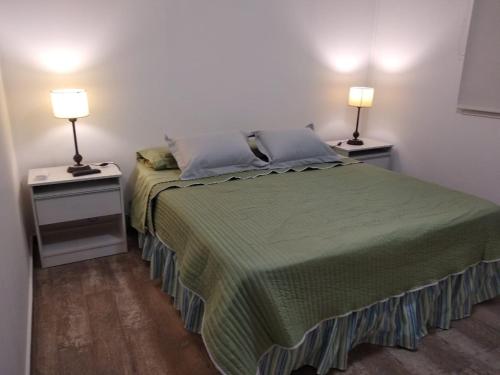 サルタにあるCabañas Campo Quijano - Desérticoのベッドルーム1室(ベッド1台付)、2泊分のスタンド(ランプ付)