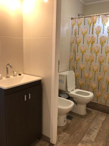 a bathroom with a toilet and a shower curtain at Cabañas Campo Quijano - Desértico in Salta