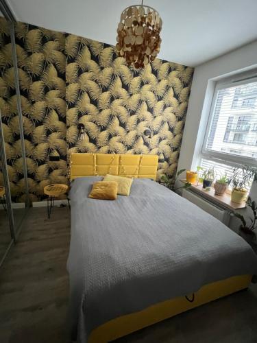 a bedroom with a large bed with a yellow headboard at Konstruktorska Chill in Warsaw