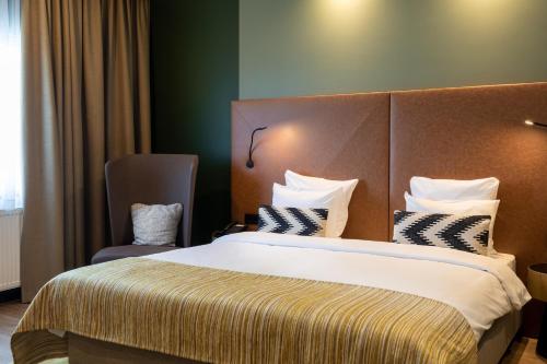 a hotel room with a large bed and a chair at Shanghai Hotel Holland in Delft