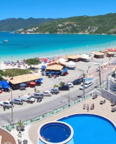 a view of a parking lot with a large pool at Arraial Praia Ap - Residence Club Praia dos Anjos in Arraial do Cabo