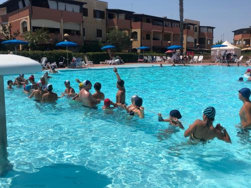 a group of people in a swimming pool at Casa EleGiò - Blue Village 2 in Marina di Pisticci