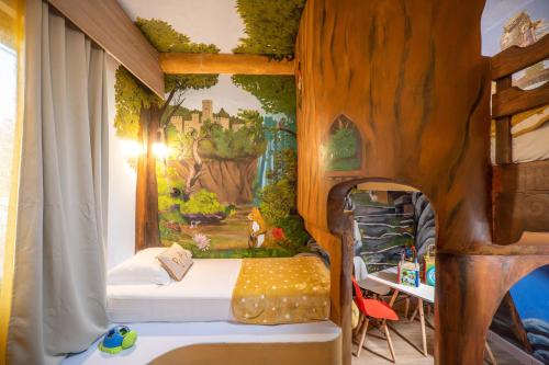 Schlafzimmer mit einem Bett mit Wandgemälde in der Unterkunft Paradisio Baby & Kinder Hotel in Stavros