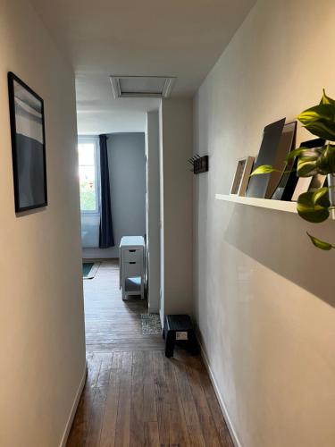 Cette chambre dispose d'un couloir avec une table et une télévision. dans l'établissement T2 Cosy proche Gare et Centre Ville - Parking Gratuit à proximité, à Lourdes
