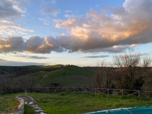 a view of a grassy hill with a cloudy sky at La casina di Helen in Montalcino