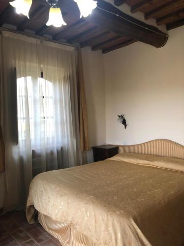 a bedroom with a large bed and a window at La casina di Helen in Montalcino