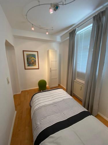 a bedroom with a bed with a green chair next to a window at Ferienwohnung Bad Laasphe Altstadt in Bad Laasphe