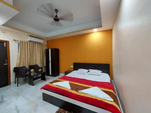 a bedroom with a bed with a ceiling fan at ICONIC Hotel Digha in Digha