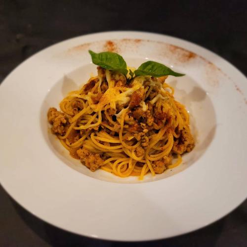 a plate of spaghetti with meat and basil on it at Arachchi Heritage in Anuradhapura