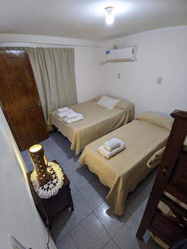 a room with two beds and a chair in it at Apart termas in Termas de Río Hondo