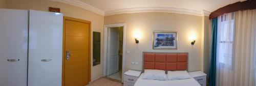 a small room with a bed and a door at Arden Hotel in Didim
