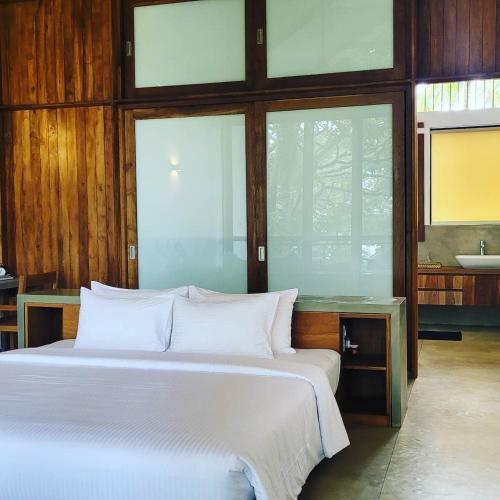 a bedroom with a white bed and a sink at Arachchi Heritage in Anuradhapura