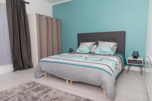 1 dormitorio con 1 cama grande y paredes azules en Appartement 70m2 hyper centre avec baignoire balnéo, en La Flèche