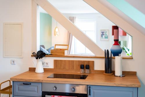 a kitchen with a counter with a sink and a staircase at Bauhaus Apartment - Netflix & Wifi in Chemnitz