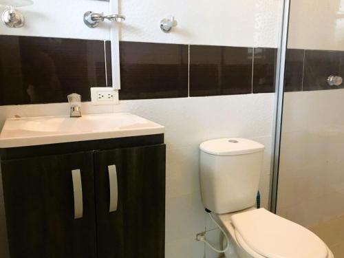 a bathroom with a toilet and a sink at La Luna by JR in Mariquita