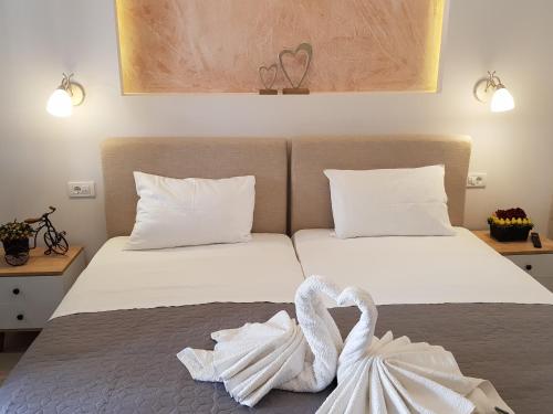 two swans towels are sitting on a bed at Virvilis Apartments in Sivota