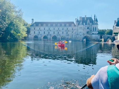 a group of people kayaking on the river in front of a castle at La LocaLuna in Civray-de-Touraine