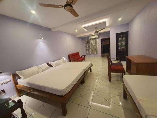 1 dormitorio con 2 camas y sala de estar en MG TOWER Hotel, en Trivandrum