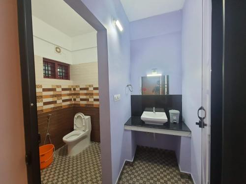 a bathroom with a toilet and a sink at MG TOWER Hotel in Trivandrum