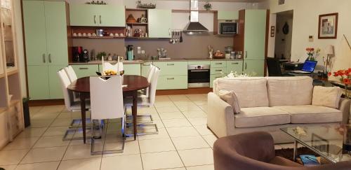 une cuisine et un salon avec une table et un canapé dans l'établissement LE PATIO, à Canet